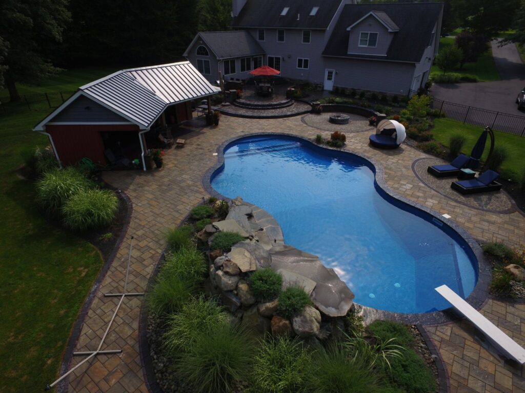 Backyard pool with fire pit, cabana and multi-level patio by Chaffee's