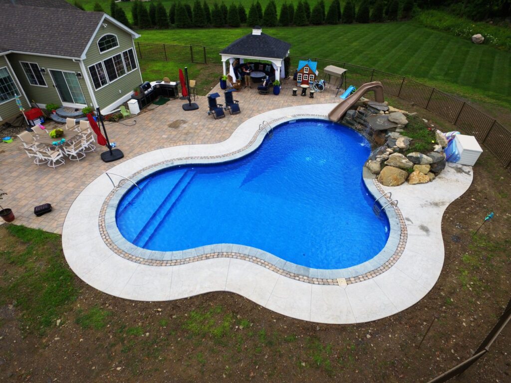 Freeform vinyl inground pool with boulder waterfall, slide and pavilion built by Chaffee's