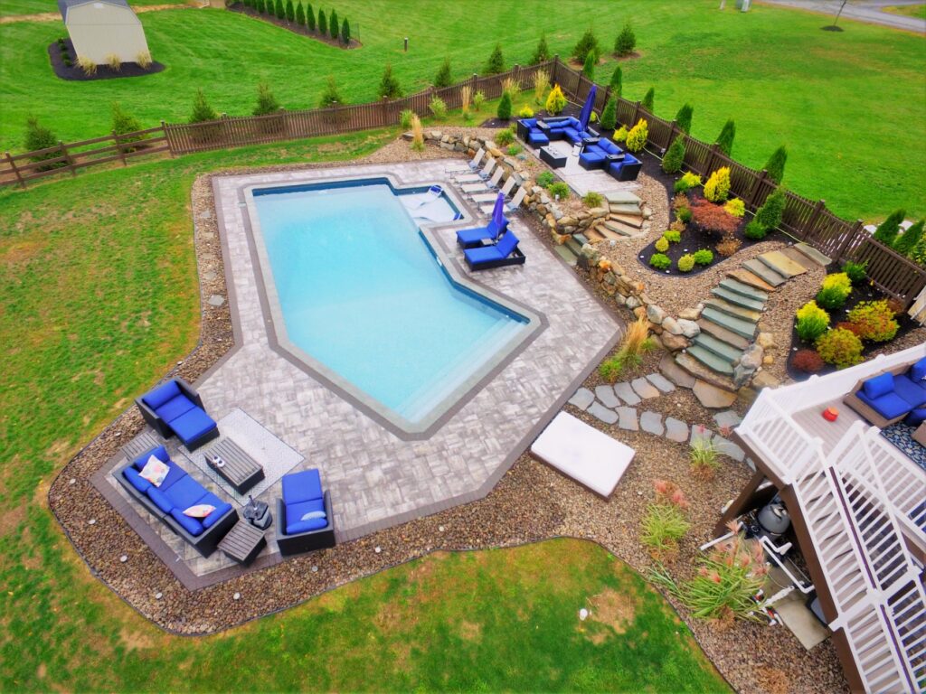 Geometric pool with tanning ledge, stone steps and landscaping by Chaffee's