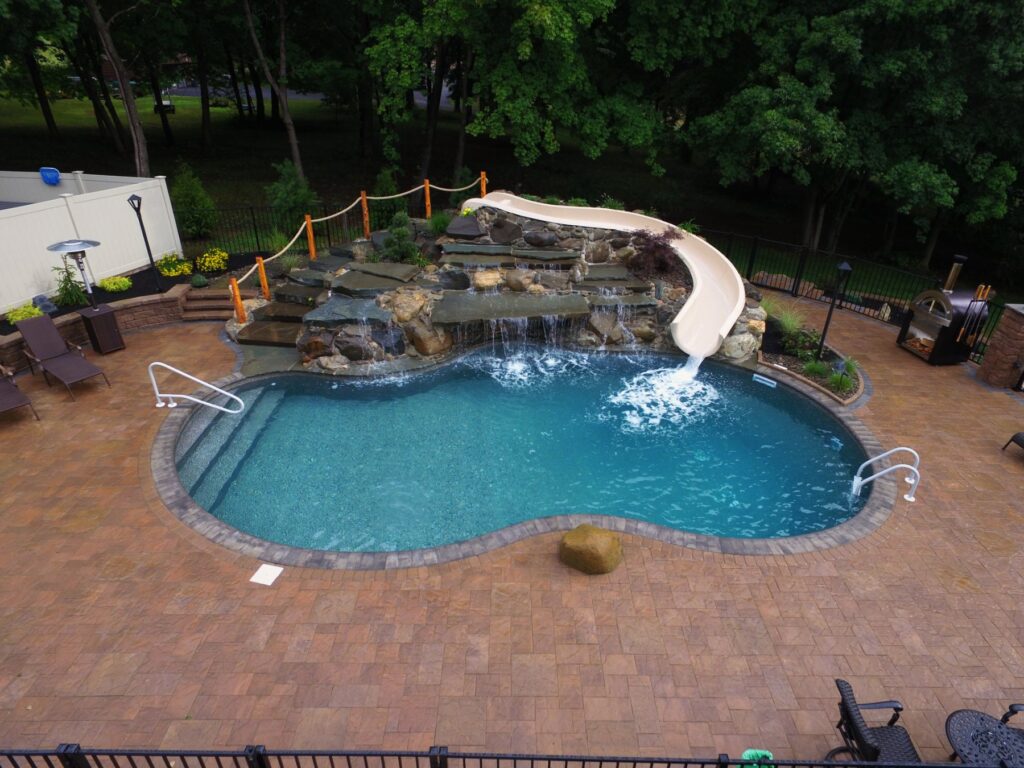 Custom inground pool with boulder waterfall and slide built by Chaffee's