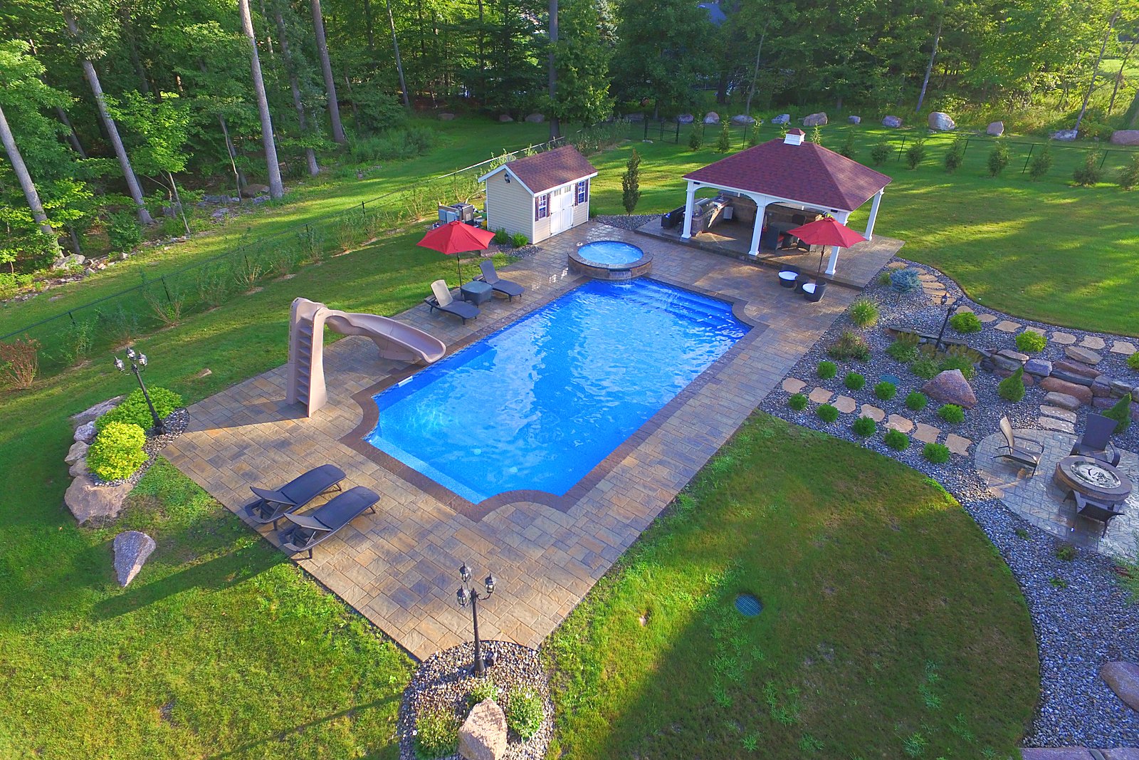 Finished Roman-end inground pool with raised spa, slide and pavilion built by Chaffee's